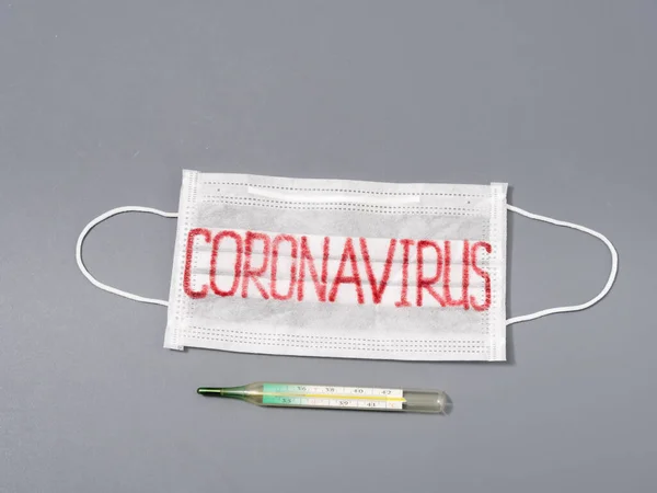 Противовирусная маска на сером фоне. Эпидемия коронавируса . — стоковое фото