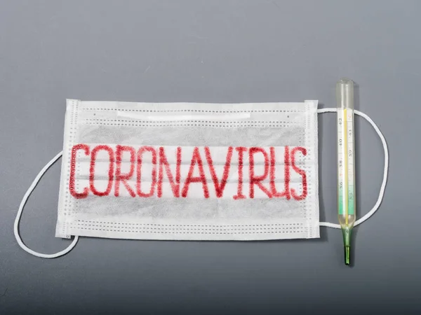 Antivirale Gesichtsmaske auf grauem Hintergrund. Coronavirus-Epidemie. — Stockfoto