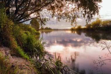 Nehrin üzerinde kırmızı mor gökyüzü bulutu ile güzel bir gün doğumu