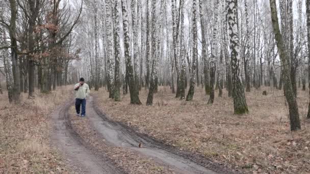 Man Loopt Door Het Herfstbos Rookt Een Sigaret 2020 — Stockvideo