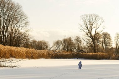 Küçük yalnız çocuk kışın karda buzda