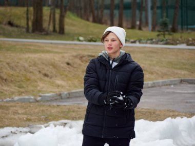 Kış eğlencesi Şapkalı neşeli genç 2020 'de kartopu oynuyor.