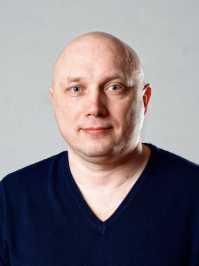 2020 'de gri arka planda kel, neşeli bir adamın portresi.