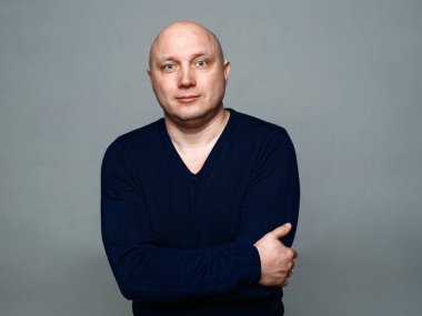 2020 'de gri arka planda kel, neşeli bir adamın portresi.