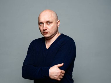 2020 'de gri arka planda kel, neşeli bir adamın portresi.