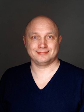 2020 'de siyah arka planda kel, neşeli bir adamın portresi.