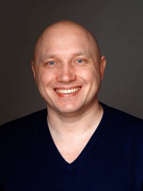 2020 'de siyah arka planda kel, neşeli bir adamın portresi.