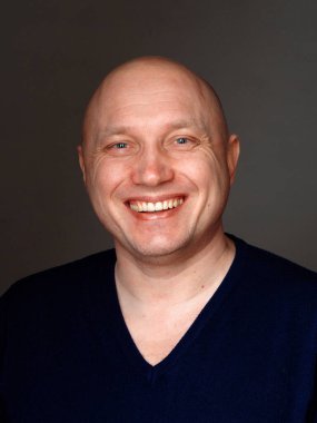 2020 'de siyah arka planda kel, neşeli bir adamın portresi.