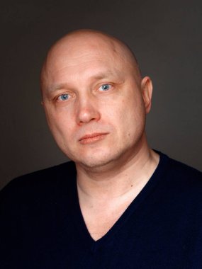 2020 'de siyah arka planda kel, neşeli bir adamın portresi.