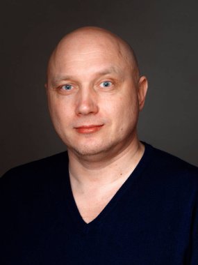 2020 'de siyah arka planda kel, neşeli bir adamın portresi.