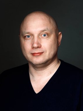 2020 'de siyah arka planda kel, neşeli bir adamın portresi.