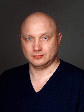 2020 'de siyah arka planda kel, neşeli bir adamın portresi.