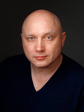 2020 'de siyah arka planda kel, neşeli bir adamın portresi.