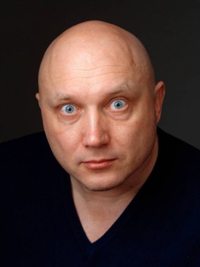 2020 'de siyah arka planda kel, neşeli bir adamın portresi.