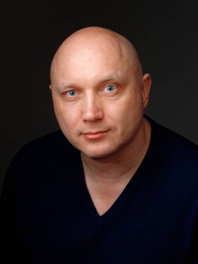 2020 'de siyah arka planda kel, neşeli bir adamın portresi.