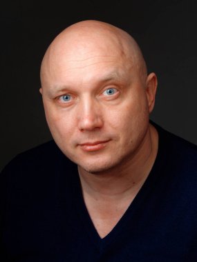 2020 'de siyah arka planda kel, neşeli bir adamın portresi.