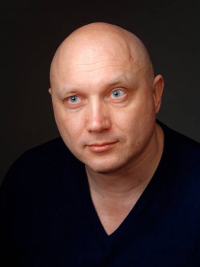 2020 'de siyah arka planda kel, neşeli bir adamın portresi.