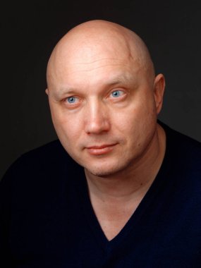 2020 'de siyah arka planda kel, neşeli bir adamın portresi.