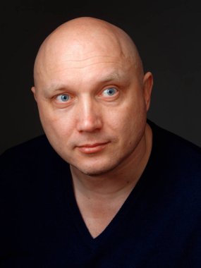 2020 'de siyah arka planda kel, neşeli bir adamın portresi.