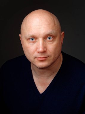 2020 'de siyah arka planda kel, neşeli bir adamın portresi.