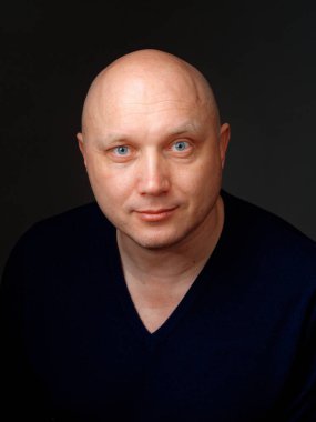 2020 'de siyah arka planda kel, neşeli bir adamın portresi.