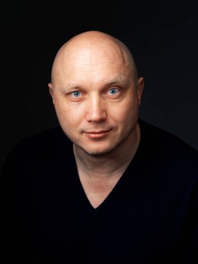 2020 'de siyah arka planda kel, neşeli bir adamın portresi.