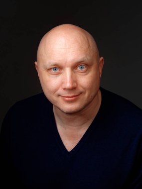 2020 'de siyah arka planda kel, neşeli bir adamın portresi.