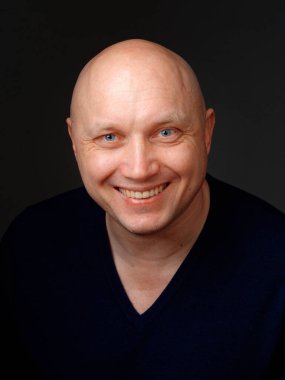 2020 'de siyah arka planda kel, neşeli bir adamın portresi.