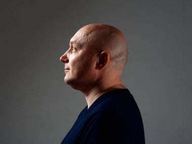 2020 'de siyah bir arka planda kel ve neşeli bir adamın portresi.