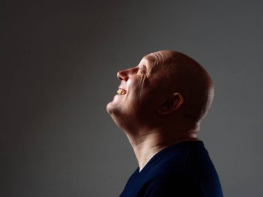 2020 'de siyah bir arka planda kel ve neşeli bir adamın portresi.