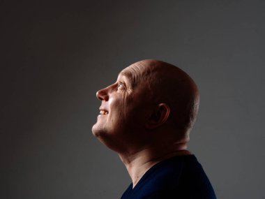 2020 'de siyah bir arka planda kel ve neşeli bir adamın portresi.