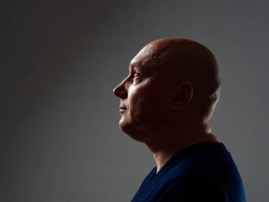 2020 'de siyah bir arka planda kel ve neşeli bir adamın portresi.