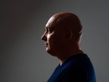 2020 'de siyah bir arka planda kel ve neşeli bir adamın portresi.