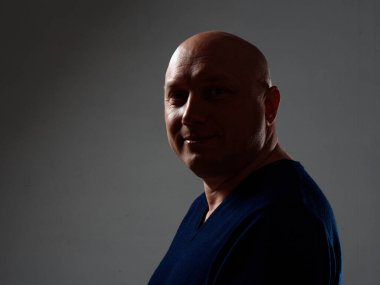 2020 'de siyah bir arka planda kel ve neşeli bir adamın portresi.