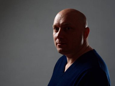 2020 'de siyah bir arka planda kel ve neşeli bir adamın portresi.