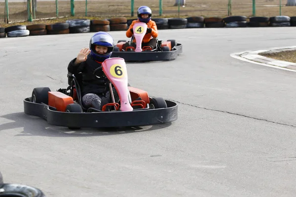 girl is driving Go-kart car with speed in a playground racing track. Go kart is a popular leisure motor sports.