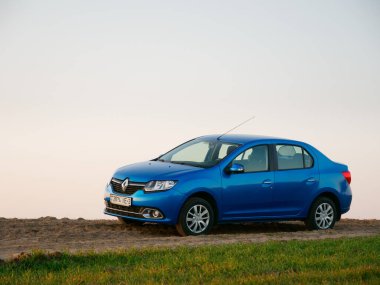 Gomel, Belarus - 8 Nisan 2020: Mavi Renault Logan arabası 2020 'de gün doğumunda bir tarlada.