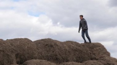 çocuk gökyüzüne karşı saman yığınıyla oynuyor