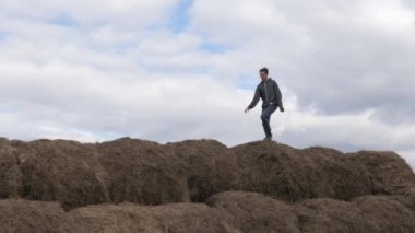 çocuk gökyüzüne karşı saman yığınıyla oynuyor