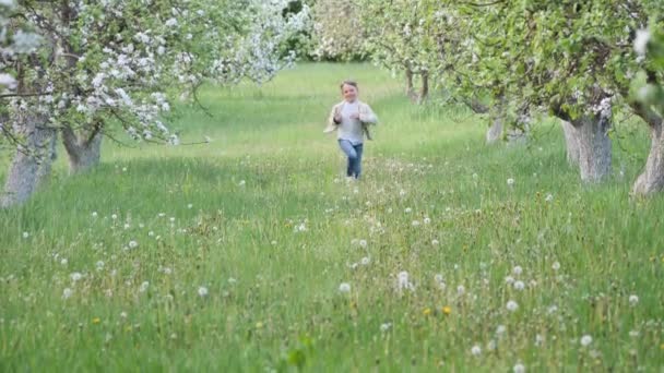 庭に咲くリンゴの木の近くの芝生の上の少年2020 — ストック動画