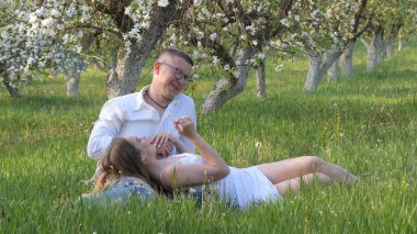 2020 bahçesindeki çiçek açan elma ağaçlarındaki genç adam ve kız.
