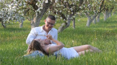 2020 bahçesindeki çiçek açan elma ağaçlarındaki genç adam ve kız.