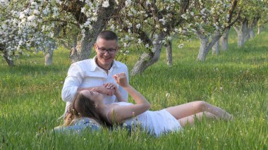 2020 bahçesindeki çiçek açan elma ağaçlarındaki genç adam ve kız.
