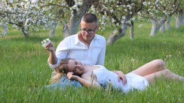 2020 bahçesindeki çiçek açan elma ağaçlarındaki genç adam ve kız.