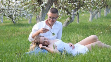 2020 bahçesindeki çiçek açan elma ağaçlarındaki genç adam ve kız.