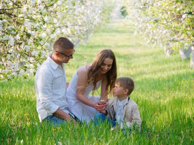 2020 bahçesindeki çiçek açan elma ağaçlarında çocuklu bir aile.
