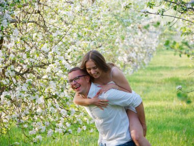 2020 bahçesindeki çiçek açan elma ağaçlarındaki genç adam ve kız.