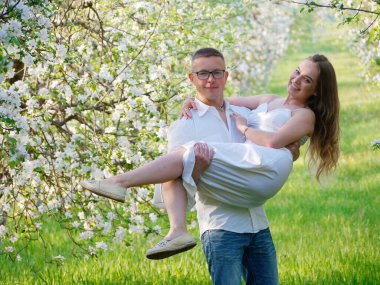 2020 bahçesindeki çiçek açan elma ağaçlarındaki genç adam ve kız.