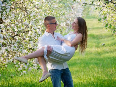 2020 bahçesindeki çiçek açan elma ağaçlarındaki genç adam ve kız.