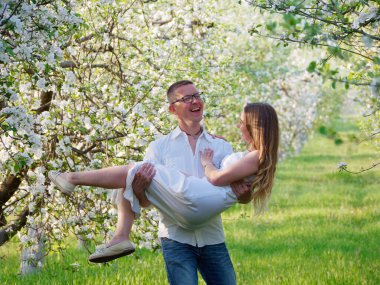 2020 bahçesindeki çiçek açan elma ağaçlarındaki genç adam ve kız.